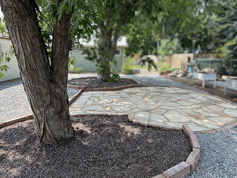 TUSCAN GARDEN FLAGSTONE AND PEA GRAVEL WITH TREE RINGS FOR PLANTING